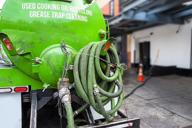 a technician pumping a grease trap in a commercial building in West Falmouth